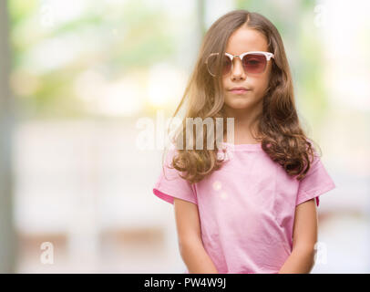 Bruna ragazza ispanica indossando occhiali da sole con un fiducioso espressione sul viso intelligente pensare grave Foto Stock