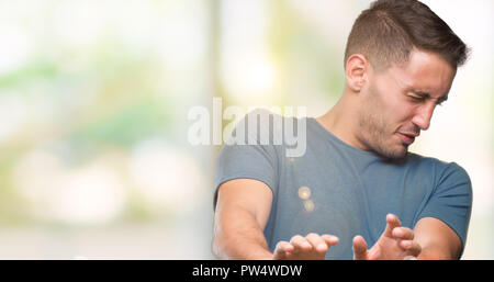 Bel giovane uomo informale disgustato espressione, orinato e timorosi facendo il disgusto di fronte perché la reazione di avversione. Con le mani alzate. Fastidioso conce Foto Stock