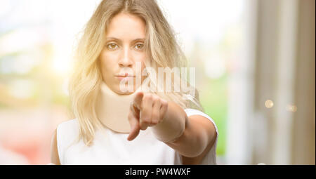 Giovani feriti donna che indossa il rinforzo del collo rivolta verso la parte anteriore con un dito Foto Stock