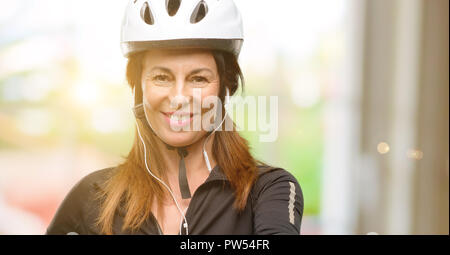 La mezza età ciclista donna utilizzare auricolari tiene per mano accogliente nella posa di handshake, esprimendo la fiducia e il concetto di successo, saluto Foto Stock