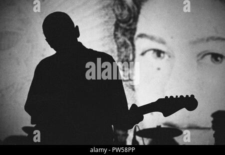 Malcolm Eden del gruppo indie pop McCarthy che si esibisce di fronte ad un ritratto della Regina al Bowen West Theatre di Bedford, 3 marzo 1990. Foto Stock