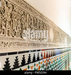 Motivi decorativi e arabo scritte sul muro del Royal Alcazar di Siviglia (Real Alcazar de Sevilla), Spagna. Foto Stock