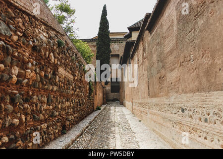 Corridoio con pareti di architettura moresca, bella arancio pareti di argilla e i dettagli. Muro fatto di grosse pietre, mattoni e argilla. Foto Stock