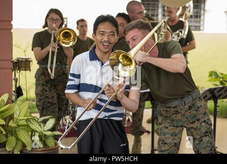 LUMUT, Malaysia (19 settembre 2017) Sgt. Colin Deeter della III Marine Expeditionary Force (III) MEF brass band suona il trombone con un Royal Navy malese sailor durante un impegno nella comunità evento presso il Rumah Wawasan Manjung Raya orfanotrofio e casa di riposo di Lumut, Malaysia come parte della formazione marittima attività (MTA) Malaysia sett. 19, 2017. MTA Malaysia 2017 è una continuazione di 23 anni di impegni marittimi tra Stati Uniti La marina e la Royal Navy malese che serve a migliorare la capacità di reciproca nel garantire la sicurezza marittima e la stabilità. Foto Stock