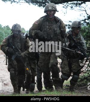 Soldati con Michigan Esercito Nazionale Società di guardia b, 1° Battaglione, centoventicinquesimo reggimento di fanteria in base fuori di Saginaw, Michigan, spostare in avanti come attaccano un bunker fortificato posizione come parte dell'ultimo evento di formazione di esercizio Viking Star 2017 a Danish Home Guard Nymindegab Training Center in Danimarca. Esercizio Viking Star 2017 è una distribuzione di oltremare per la formazione (ODT) che coinvolgono l'1-125esimo reggimento di fanteria dell'esercito del Michigan Guardia Nazionale. Soldati dal Bravo società in base a Saginaw, Michigan, condurre formazione combattivo, orienteering e joint live fire esercizi con la danese Hom Foto Stock