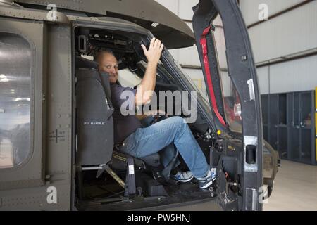 Fire Chief Bob Sharp della penisola dei Vigili del Fuoco in Cleveland, Oklahoma, esperienze a mani su look in un UH-60 Blackhawk elicottero mentre frequentano l'operazione "Boss" di sollevamento all'esercito Aviation Support Facility #2 in Tulsa, Oklahoma, Martedì, Settembre 20, 2017. Operazione di sollevamento Boss trasportato circa 30 ai datori di lavoro di Camp Gruber, Oklahoma, dove hanno visitato i loro dipendenti che stavano conducendo pre-formazione di mobilitazione. Foto Stock