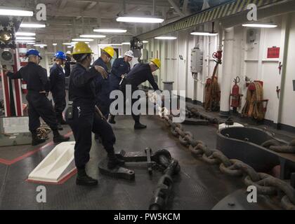 SAN DIEGO (sett. 21, 2017) velisti assegnati all'assalto anfibio nave USS Makin Island (LHD 8) abbassare la dritta catena di ancoraggio durante una catena off-load nel castello di prua. Makin Island è attualmente in bacino di carenaggio di General Dynamics National la siderurgia e la costruzione navale Company (NASSCO) per un deposito di manutenzione di livello di disponibilità. Foto Stock