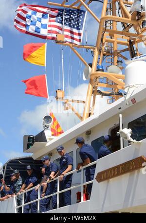 Il suo equipaggio dalla Guardacoste Oliver Berry (WPC 1124) attendere per sbarcare durante una cerimonia di arrivo per la fresa a Coast Guard Base Honolulu, Sett. 22, 2017. Queste frese con loro una maggiore efficacia nelle operazioni di ricerca e salvataggio farà le acque che circondano le isole principali delle Hawaii un luogo molto più sicuro per i diportisti ricreative e gli utenti delle vie navigabili. Foto Stock