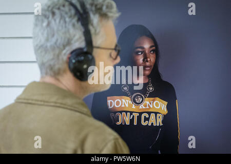 Lewisham, a sud-est di Londra, UK, 12 ott 2018. Visitatori guardare uno dei nuovi ritratti da Des Willie. "Ieri e Oggi" si apre con una visualizzazione privata. Il Landmark exhibition celebra i giovani nella zona di Lewisham, con foto della leggendaria serie 1977 'lovers rock" di John Goto, e le nuove foto di Lewisham's oggi i giovani dal fotografo Des Willie. Ottobre è anche storia nero il mese e la mostra in parte i riferimenti a tale. Credito: Imageplotter News e sport/Alamy Live News Foto Stock