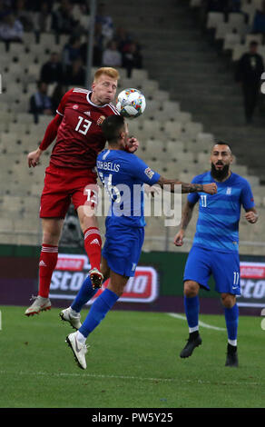 Atene, Grecia. Xii oct, 2018. Dimitris Kourbelis (C) della Grecia il sistema VIES con Ungheria Zsolt Kalmar (L) durante il campionato C gruppo match delle Nazioni UEFA League ad Atene, Grecia, Ottobre 12, 2018. La Grecia ha vinto 1-0. Credito: Marios Lolos/Xinhua/Alamy Live News Foto Stock