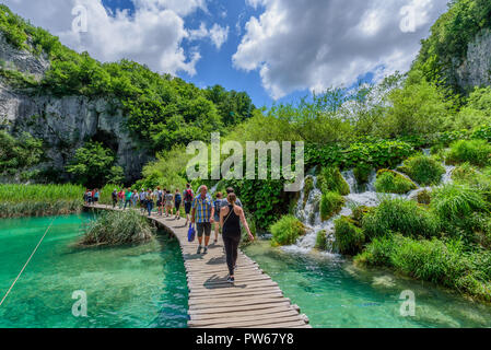 Il parco nazionale di Plitvice, Croazia - 8 giugno 2018: SORPRENDENTE turistico percorso di legno nella colorata deep forest con laghi puliti e spettacolari waterfal Foto Stock