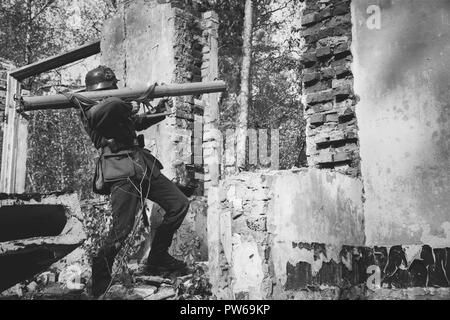 Ri-enactor vestito come il tedesco della Wehrmacht Soldato di fanteria nella guerra mondiale II Fuoco Aperto da anti-serbatoio cannone durante la rievocazione storica. Foto in bianco e nero Foto Stock