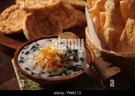 Es Dawet Ireng, i giavanesi iced dessert di gelatina di nero a base di noodle realizzato dal risone arrosto paglia; miscelato con latte di cocco e la zuppa di palm di zucchero. Foto Stock