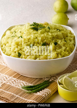 BATATA POHA realizzato da riso soffiato fiocchi di patate e cipolle. servita con calce e peperoncini verdi Foto Stock