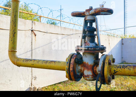 I vecchi rusty valvola sul tubo del gas giallo arrugginito vernice colorata. Foto Stock