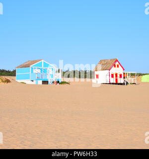 Spiaggia di colorate case a Costa da Caparica Beach a Lisbona, con un cielo blu e la spiaggia di sabbia fine e dorata view Foto Stock