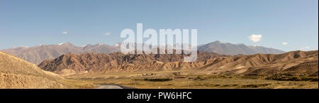 Panorama di case lungo la strada attraverso il Chu River Valley Gorge nelle zone rurali del Kirghizistan. Foto Stock