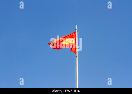 Bandiera del Kirghizistan sul pennone contro il cielo blu a Bishkek, Kirghizistan. Foto Stock