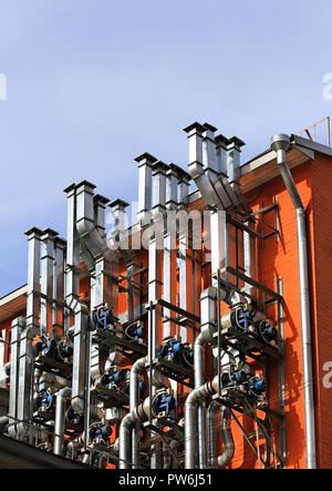 Tubi di ventilazione e gli attuatori sulla parete di un edificio industriale Foto Stock