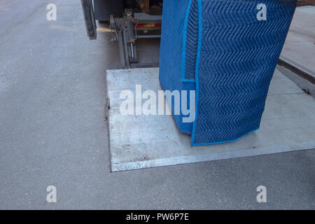 Blue paded telo protettivo per lo spostamento sul retro di un autocarro del portellone di sollevamento pwr Foto Stock