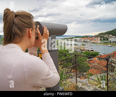 Donna che utilizza a gettone telescopio panoramico. Foto Stock