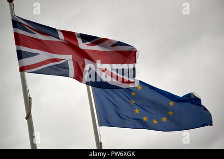British uk unione bandiera e bandiera UE nel buio cielo tempestoso England Regno Unito Foto Stock