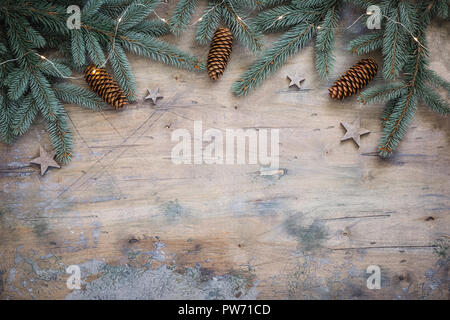 Natale piatto scuro composizione laici con rami di abete, stelle e coni in legno sfondo vintage. Vista superiore, spazio di copia Foto Stock