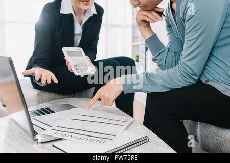 Professional agente di assicurazione che mostra la quantità di caso assicurativo prodotto per la scaltra casalinga nel soggiorno. imprenditrice calcul holding Foto Stock
