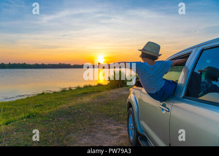 Padre e figlio sono la riproduzione sul lago al tramonto. Le persone a divertirsi sul campo. Famiglia-amichevole di concetto e vacanze estive Foto Stock