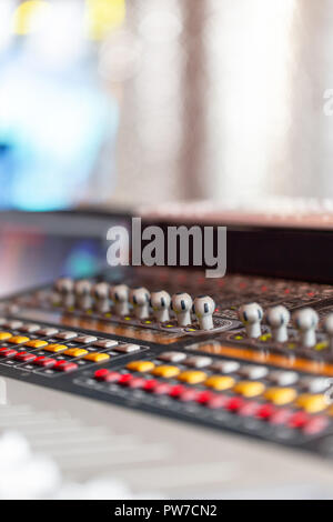 Console di miscelazione di materiali leggeri operatore al concerto. Per la registrazione del suono miscelazione in studio con scrivania da parte di un tecnico o di un produttore di musica Foto Stock