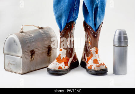 Scatola di pranzo per la scuola con un giovane ragazzo in stivali da cowboy. Foto Stock