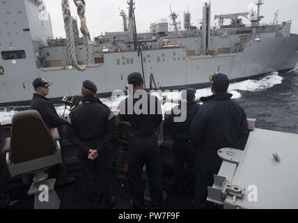 Oceano atlantico (sett. 19, 2017) Il comandante della Arleigh Burke-class guidato-missile destroyer USS Winston S. Churchill (DDG 81), la Cmdr. Tom Van Scoten, sinistra e equipaggio dirigere un rifornimento in mare con la forza militare di comando Sealift carichi secchi e munizioni nave USNS Medgar Evers (T-AKE 13) dal ponte porta ala sett. 19, 2017. Winston Churchill S., homeported alla stazione navale di Norfolk, sta conducendo operazioni navali negli Stati Uniti Sesta flotta area di operazioni a sostegno degli Stati Uniti per gli interessi di sicurezza nazionali in Europa. Foto Stock