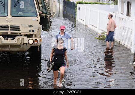 Puerto Ricans tentare di raggiungere le loro case nella zona allagata dopo il percorso di uragano Maria. Foto Stock