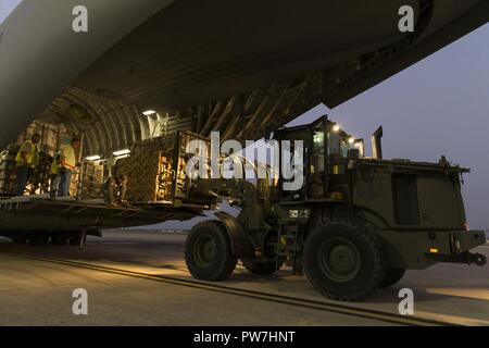 Stati Uniti Avieri con la logistica 502nd disponibilità squadrone un carico C-17 Globemaster III a base comune San Antonio-Lackland, Texas, per l'uragano Maria soccorsi sett. 25, 2017. Il 502nd LRS sono state sostenendo gli sforzi di rilievo poiché uragano Harvey e hanno preparato e spedito oltre 800.000 libbre di acqua, cibo e generi di prima necessità. Foto Stock