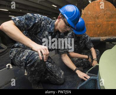 PORTSMOUTH, Va. (sett. 22, 2017) Seaman Matthew Boeger, sinistra, da Kansas City, Mo., marinaio e Seth Horvath, da Twin Falls, Idaho, la sabbia capstone a bordo della portaerei USS Dwight D. Eisenhower CVN (69) (IKE). Ike è sottoposto a una prevista disponibilità incrementale (PIA) a Norfolk Naval Shipyard durante la fase di manutenzione della flotta ottimizzato il piano di risposta (OFRP). Foto Stock