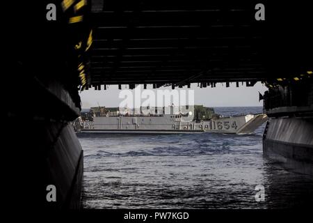 Stati Uniti Navy Landing Craft, utilità 1654, il trasporto di forniture di soccorso, personale e attrezzature a Puerto Rico, esce bene mazzo di assalto anfibio nave USS Kearsarge (LHD 3) nel Mar dei Caraibi, Sett. 26, 2017. Il ventiseiesimo MEU è il supporto di Federal Emergency Management Agency (FEMA), il piombo agenzia federale, per aiutare le persone colpite dall'uragano Maria per ridurre al minimo la sofferenza ed è un componente del complessivo intero-di-risposta del governo sforzo. Foto Stock