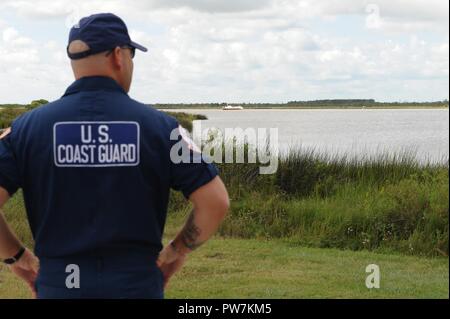 Coast Guard Petty Officer di prima classe Tindol Bret, una scienza marina tecnico assegnato al golfo Strike Team, conduce una valutazione preliminare di una nave spiaggiata, Dickinson, Texas, Sett. 26, 2017. La Guardia Costiera ha collaborato con il Texas terra generale Ufficio, il Texas Commissione sulla qualità ambientale, e gli altri enti federali, statali e degli enti locali per il recupero di petrolio e di materiali pericolosi da navi danneggiate prima di rimuovere i pescherecci dalla zona di acque dopo l uragano Harvey. Foto Stock