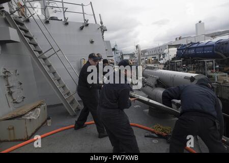 FASLANE in Scozia (sett. 22, 2017) velisti assegnati al Arleigh Burke-class guidato-missile destroyer USS Winston S. Churchill (DGG 81) preparare una linea di combustibile sett. 22, 2017. Winston Churchill S., homeported alla stazione navale di Norfolk, sta conducendo operazioni navali negli Stati Uniti Sesta flotta area di operazioni a sostegno degli Stati Uniti per gli interessi di sicurezza nazionali in Europa. Foto Stock