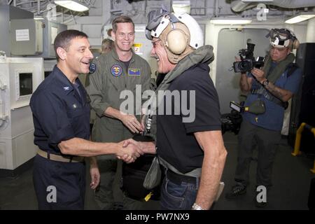 Mar dei Caraibi (sett. 26, 2017) Capt. David K. Guluzian (sinistra), comandante della Amphibious Assault nave USS Kearsarge LHD (3), posteriore e ADM. Jeff Hughes (centro), Commander, Expeditionary Strike gruppo 2, Saluto Geraldo Rivera nel ponte di volo di classificazione come Rivera arriva a bordo di prendere un tour della nave e parlare con il personale e leadership. Kearsarge è assistere con i soccorsi dopo il passaggio dell uragano Maria. Il Dipartimento della difesa è il supporto di FEMA, il piombo agenzia federale, per aiutare le persone colpite dall'uragano Maria per ridurre al minimo la sofferenza ed è un componente del overa Foto Stock