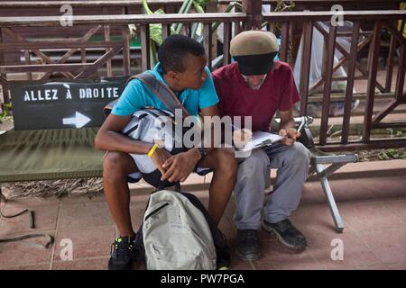 I cittadini statunitensi Naya Shargel e suo padre David Shargel, compilare la documentazione di evacuazione a Douglas-Charles Aeroporto di Melville Hall, Dominica, Sett. 26, 2017. Naya è stata separata da suo padre durante l uragano Maria; i due sono stati riuniti dopo tre giorni di ricerca in base al servizio degli Stati Uniti i membri con Joint Task Force - Isole Sottovento. Su richiesta del Dipartimento di Stato, JTF-li ha distribuito degli aerei e i membri del servizio per assistere il sistema volontario di evacuazione di cittadini statunitensi della Dominica. La task force è un militare statunitense di unità composta di Marines, soldati, marinai e aviatori, e rappresenta per gli Stati Uniti Foto Stock