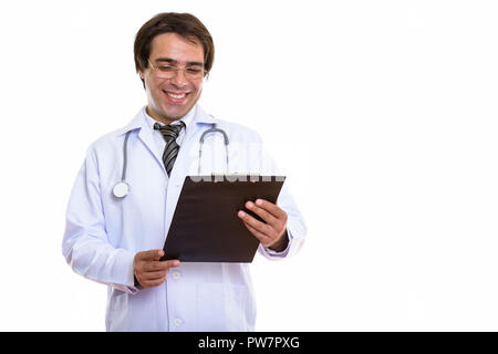Studio shot di giovani felici uomo persiano medico sorridere mentre leggi Foto Stock