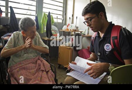 Vega Baja, PR, Settembre 27, 2017 - superstite Miguelina Olivo colloqui con Axel Ayala, assistenza individuale specialista, circa le sue precedenti esperienze con gli uragani. Un team di assistenza individuale specialisti&nbsp;visitato un rifugio situato presso il lino Padr&oacute;n di alta scuola per aiutare i sopravvissuti registrarsi con FEMA. Yuisa Rios/FEMA Foto Stock