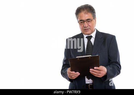 Studio shot di senior imprenditore persiano lettura sulla clipboard Foto Stock