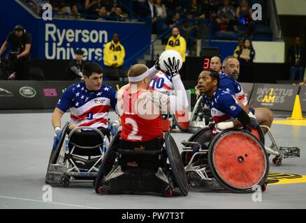 Stati Uniti Marine Corps Sgt. Ivan Sears (sinistra) e U.S. Marine Corps veterano Anthony McDaniel (a destra), i membri del team statunitense, sfida un giocatore avversario durante il Rugby in carrozzina finali all'2017 Invictus giochi in Mattamy Centro Atletico a Toronto, Canada, Sett. 28, 2017. La Invictus giochi sono stati stabiliti dal principe Harry del Galles nel 2014 e hanno riunito più di 550 feriti e veterani feriti a prendere parte a 12 adaptive eventi sportivi. Foto Stock