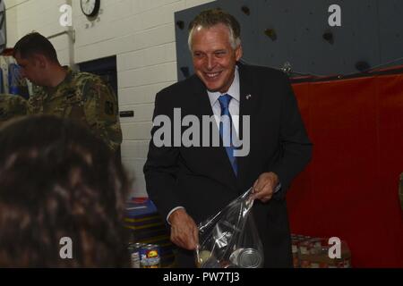 Virginia Gov. Terry McAuliffe animali cibo zaini con il generale Stanford gli studenti della scuola elementare durante una visita alla base comune Langley-Eustis, Virginia, Sett. 29, 2017. Questo evento ha contribuito a Newport News scuole pubbliche' gli studenti a capire la corretta nutrizione, e ha incluso un nuovo parco giochi scoprimento. Foto Stock