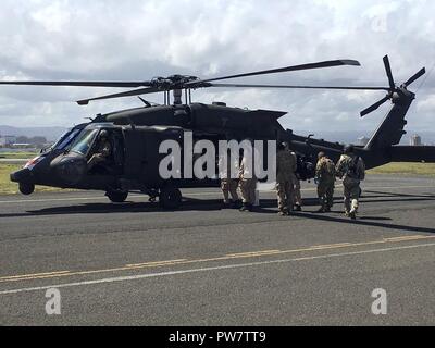 SAN JUAN, Puerto Rico - Disaster l'assistenza medica ai membri del team di bordo un HH-60 medevac Blackhawk elicottero dal 101st combattere la Brigata Aerea, 101st Airborne Division (Air Assault) a Fernando Luis Ribas Dominicci aeroporto, Sett. 29. L'elicottero è uno degli otto aerei la divisione distribuito a Puerto Rico, Sett. 27. Esso, insieme ad altri cinque elicotteri, trasportato tre medici di emergenza i team di assistenza dall'aeroporto negli ospedali di Arecibo, Mayagüez e Ponce. Foto Stock