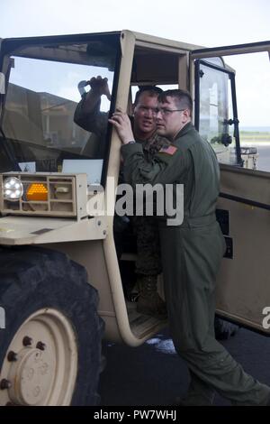 Stati Uniti Marine Cpl. Michael A. Fleenor, sinistra, una apparecchiatura pesante operatore con Joint Task Force - Isole Sottovento, E DEGLI STATI UNITI Air Force Staff Sgt. Nolan R. Brandt, un C-130J loadmaster con la 39th Airlift Squadron, discutere il piano per lo scarico di prodotti alimentari da una C-130J Hercules al Douglas-Charles Aeroporto di Melville Hall, Dominica, Sett. 29, 2017. L'aeromobile consegnato il cibo per essere distribuiti a persone in stato di bisogno presso l'aeroporto. Su richiesta dei paesi partner e il Dipartimento di Stato e gli Stati Uniti Agenzia per lo Sviluppo Internazionale, JTF-li ha distribuito degli aerei e i membri del servizio a zone in t Foto Stock