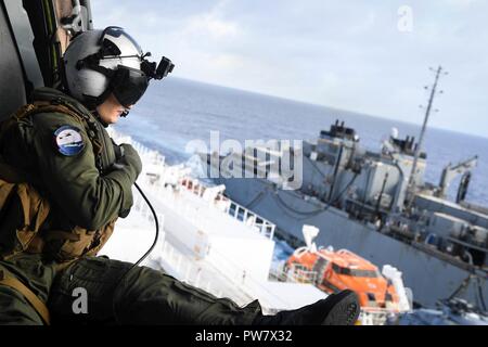 Oceano atlantico (ott. 1, 2017) - Naval Air Crewman (elicottero) terza classe Justin McCrary, assegnato al 'Sea Cavalieri' di elicottero di mare squadrone di combattimento (HSC) 22, partecipa a un rifornimento verticale con la forza militare di comando Sealift nave ospedale USNS Comfort (T-AH 20) e trasporto di carichi secchi e munizioni nave USNS William McLean (T-AKE 12). Il comfort è in corso per sostenere l'assistenza umanitaria in Puerto Rico. Il Dipartimento della difesa è di sostenere la Federal Emergency Management Agency, il piombo agenzia federale, per aiutare le persone colpite dall'uragano Maria per ridurre al minimo la sofferenza ed è o Foto Stock