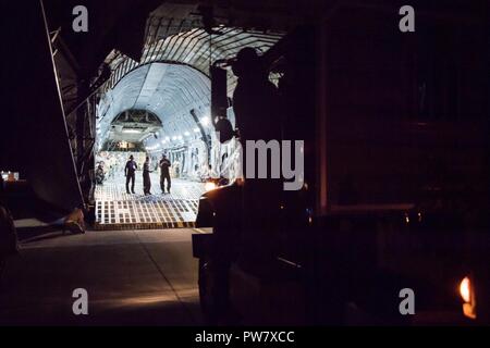 Papa Army Airfield, N.C. - Aviatori dal 43d Aria Mobilità Squadron qui, e dal ventiduesimo Airlift Squadron a Travis Air Force Base in California, preparatevi a caricare un 45.000-pound Federal Aviation Administration generatore di potenza su un C5 Super galassia sulla rampa verde qui sett. 27. Il generatore sarà utilizzata per fornire potenza per il controllo del traffico aereo operazioni in San Juan, Puerto Rico, dopo l'uragano Maria strike sull'isola, assicurando il costante flusso di aiuti umanitari. Avieri in 43d AMS ha anche ricevuto e pallettizzato acqua e pasti che sarà consegnato insieme con il generatore. Foto Stock