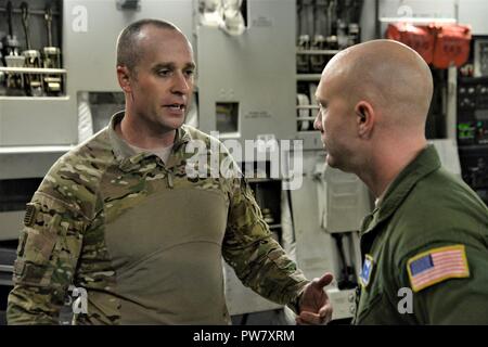 Il personale Sgt. Giacobbe Wright, 3d Airlift Squadron raggiungere 7170 loadmaster, parla con il Tech. Sgt. Jason Michel, 123contingenza Gruppo di risposta delle forze di sicurezza leader di squadra in una C-17 Globemaster III durante un uragano missione di rilievo a San Juan Luis Muñoz Marín Aeroporto di San Juan, Puerto Rico, a sett. 30, 2017. Raggiungere 7170 consegnato 118 mila libbre di pasti pronti da mangiare e acqua in bottiglia per essere distribuito in tutta l'devastato Puerto Rico con l aiuto di aviatori da 123contingenza Gruppo di risposta. Foto Stock